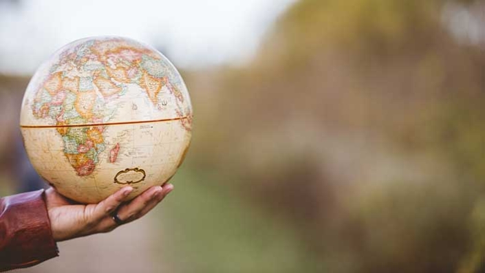 Hand holding globe 711×400